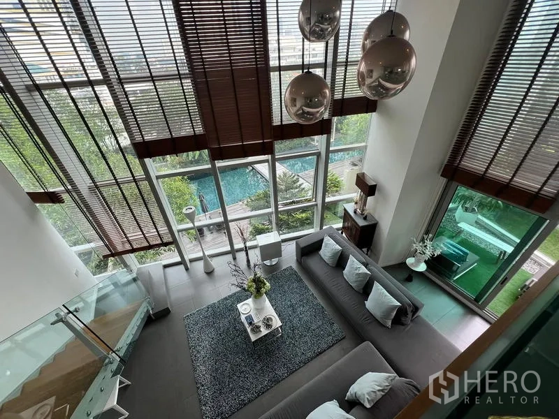 Condominium for sale in Khlong San, Bangkok - View from the mezzanine over the living room with floor-to-ceiling windows and swimming pool outlook.
