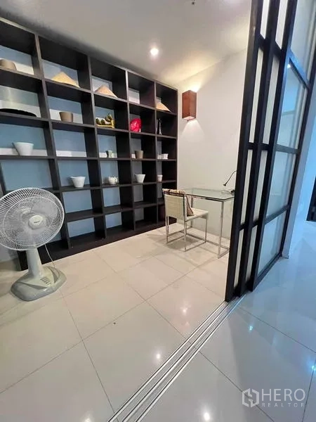 公寓 出租在Ratchathewi, Bangkok - 书房角，玻璃书桌与通高嵌入式书架。