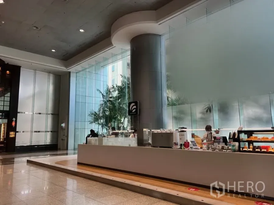 零售空间 出租在Bang Rak, Bangkok - Silom 现代大堂，挑高空间，落地玻璃与抛光石材地面，设有内建零售柜台。