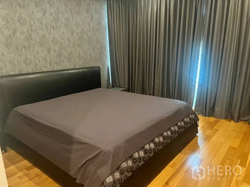 公寓 出租在Bangkok - 主卧木地板，特大床与落地遮光窗帘。