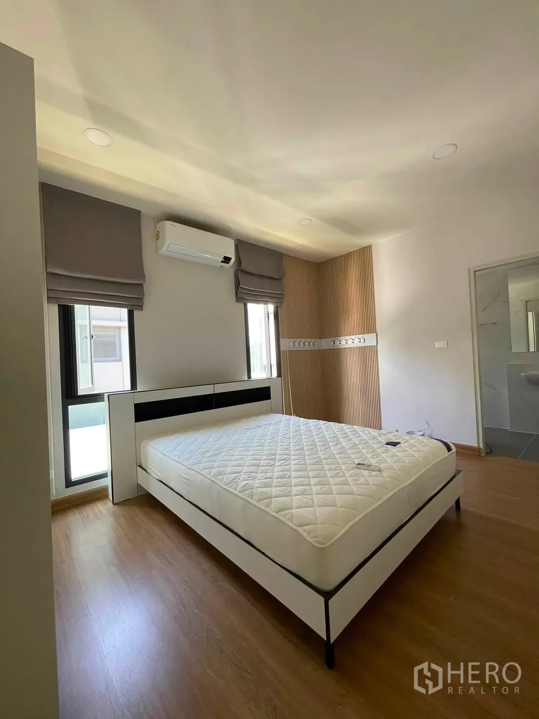 Detached House for rent in Bang Phli, Samut Prakan - Bedroom view showing the bed, feature slat wall, windows, and a doorway.