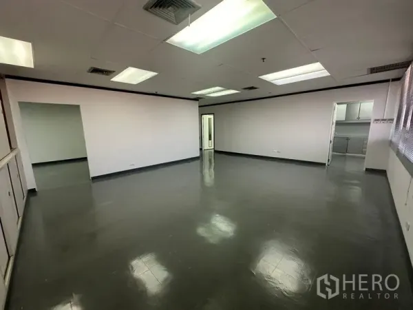 办公空间 出租在Yan Nawa, Bangkok - 宽敞开放式办公区，白墙灰地面，顶置多组灯具。