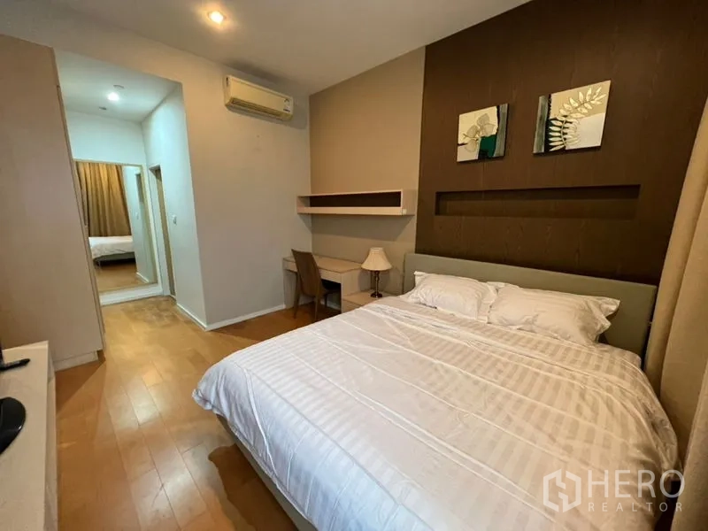 Condominium for rent in Chatuchak, Bangkok - Bedroom with queen bed, wall shelving, air conditioner and warm wood flooring