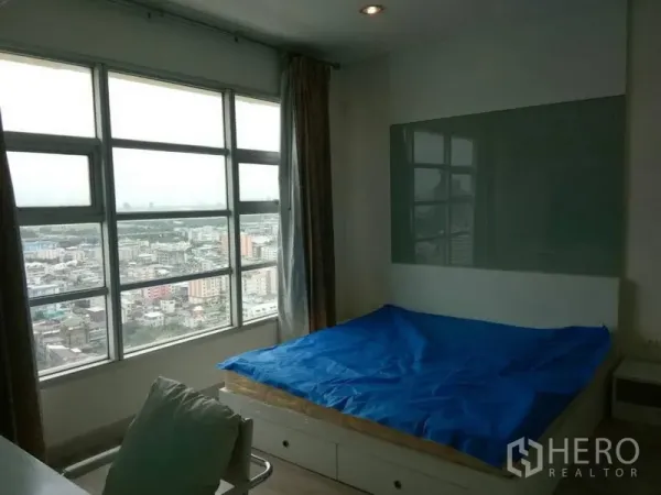 公寓 出租在Ratchathewi, Bangkok - 卧室双人床，宽幅窗户欣赏城市天际线。