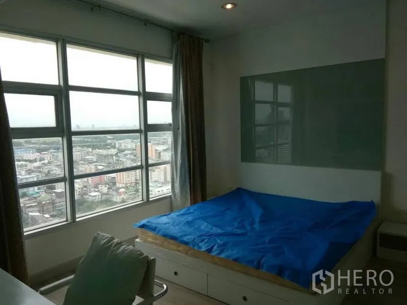 公寓 出租在Ratchathewi, Bangkok - 卧室双人床，宽幅窗户欣赏城市天际线。