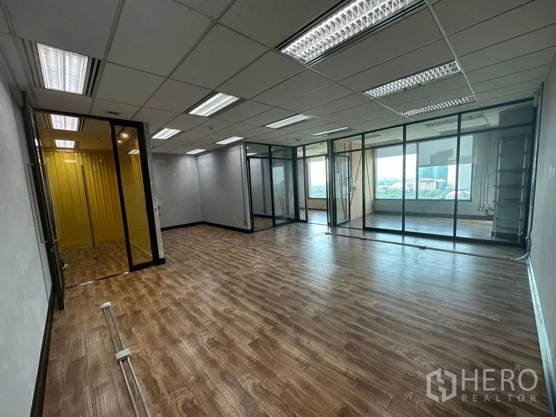Office Space for rent in Chatuchak, Bangkok - Open-plan workspace with drop ceiling lighting and glass-partitioned meeting rooms overlooking Bangkok.