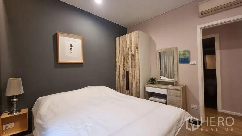 公寓 出租在Watthana, Bangkok - 客卧一角，衣柜、梳妆台与柔和照明。