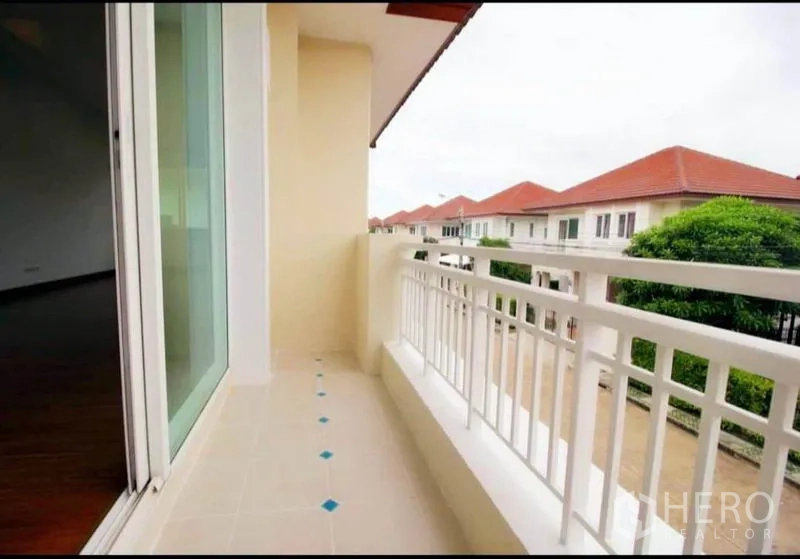 Detached House for rent or sale in Bang Yai, Nonthaburi - Upper-floor balcony with white railing overlooking a quiet residential street.