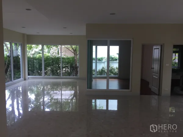 Detached House for sale in Saphan Sung, Bangkok - Bright corner living area with floor‑to‑ceiling sliding windows overlooking a private garden.