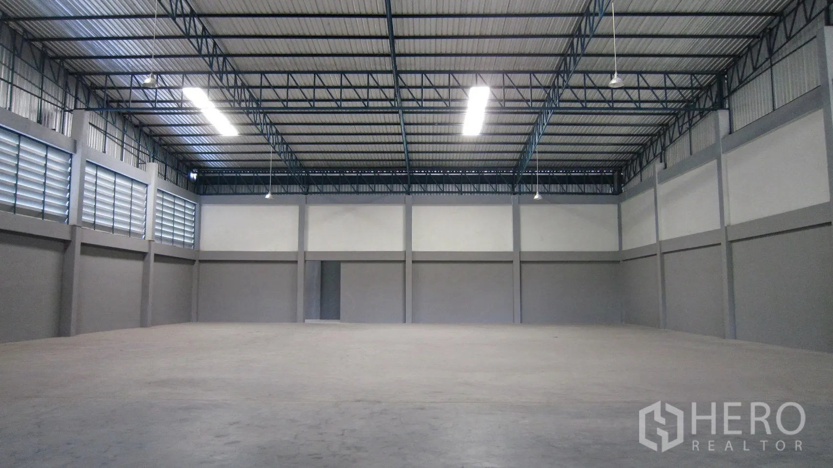 仓库 for rent in Bang Sao Thong, Samut Prakan - 大面积存储大厅，高顶下悬挂照明与通风百叶。