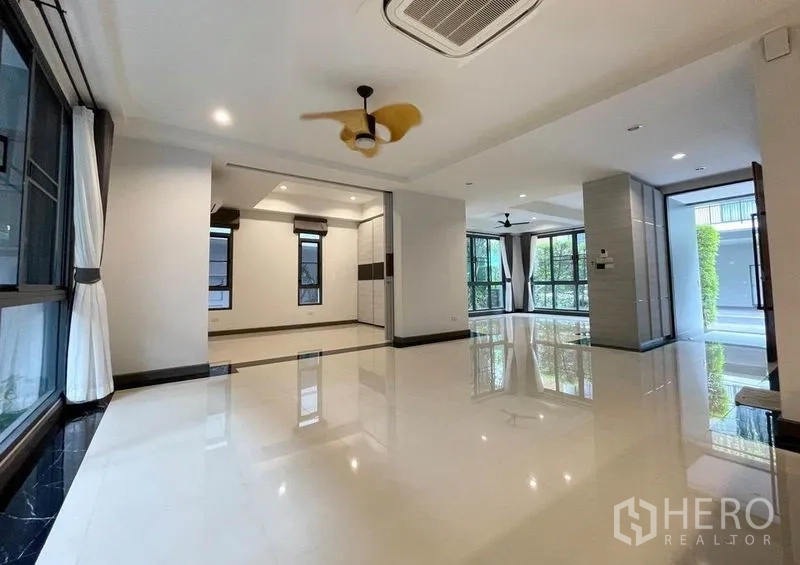 บ้าน ให้เช่าในBang Na, Bangkok - โถงนั่งเล่นแบบโอเพ่นสเปซ พื้นเงา หน้าต่างบานใหญ่และพัดลมเพดาน