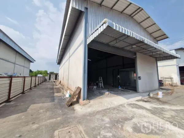 คลังสินค้า ให้เช่าในBang Khun Thian, Bangkok - ด้านหน้าโกดังผนังเมทัลชีท ประตูม้วนขนาดใหญ่ พร้อมทางรถเข้าออกในบางขุนเทียน