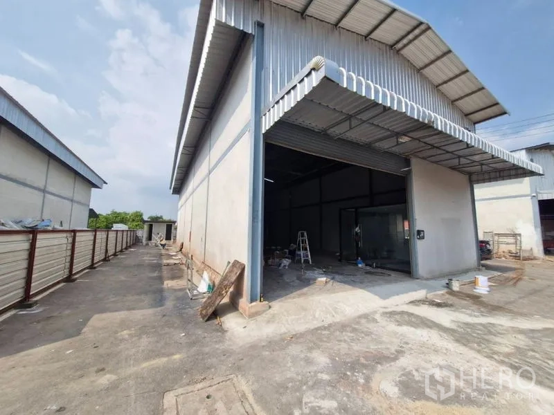 คลังสินค้า ให้เช่าในBang Khun Thian, Bangkok - ด้านหน้าโกดังผนังเมทัลชีท ประตูม้วนขนาดใหญ่ พร้อมทางรถเข้าออกในบางขุนเทียน