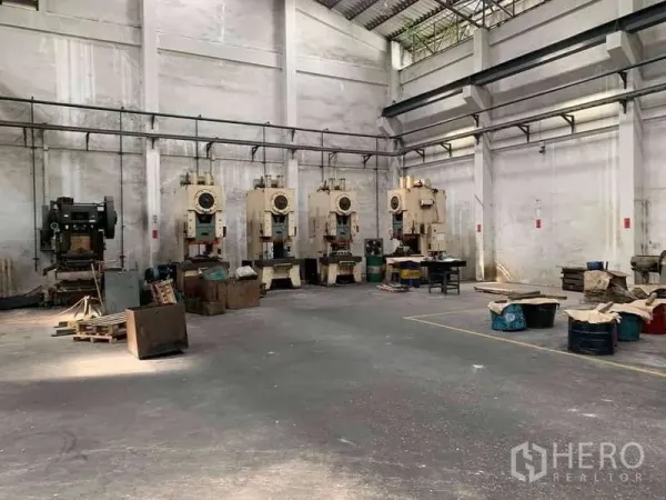 Factory for rent in Phra Samut Chedi, Samut Prakan - Row of stamping presses inside high‑ceiling warehouse with ventilated walls.