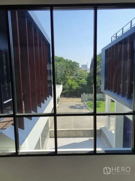 Detached House for rent in Phra Khanong, Bangkok - View from a window over the central driveway and green trees.