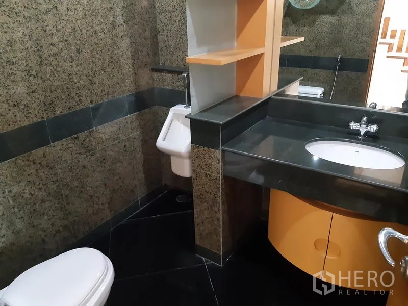 Condominium for rent in Khlong Toei, Bangkok - Granite-finished bathroom featuring a vanity, sink, toilet and urinal.