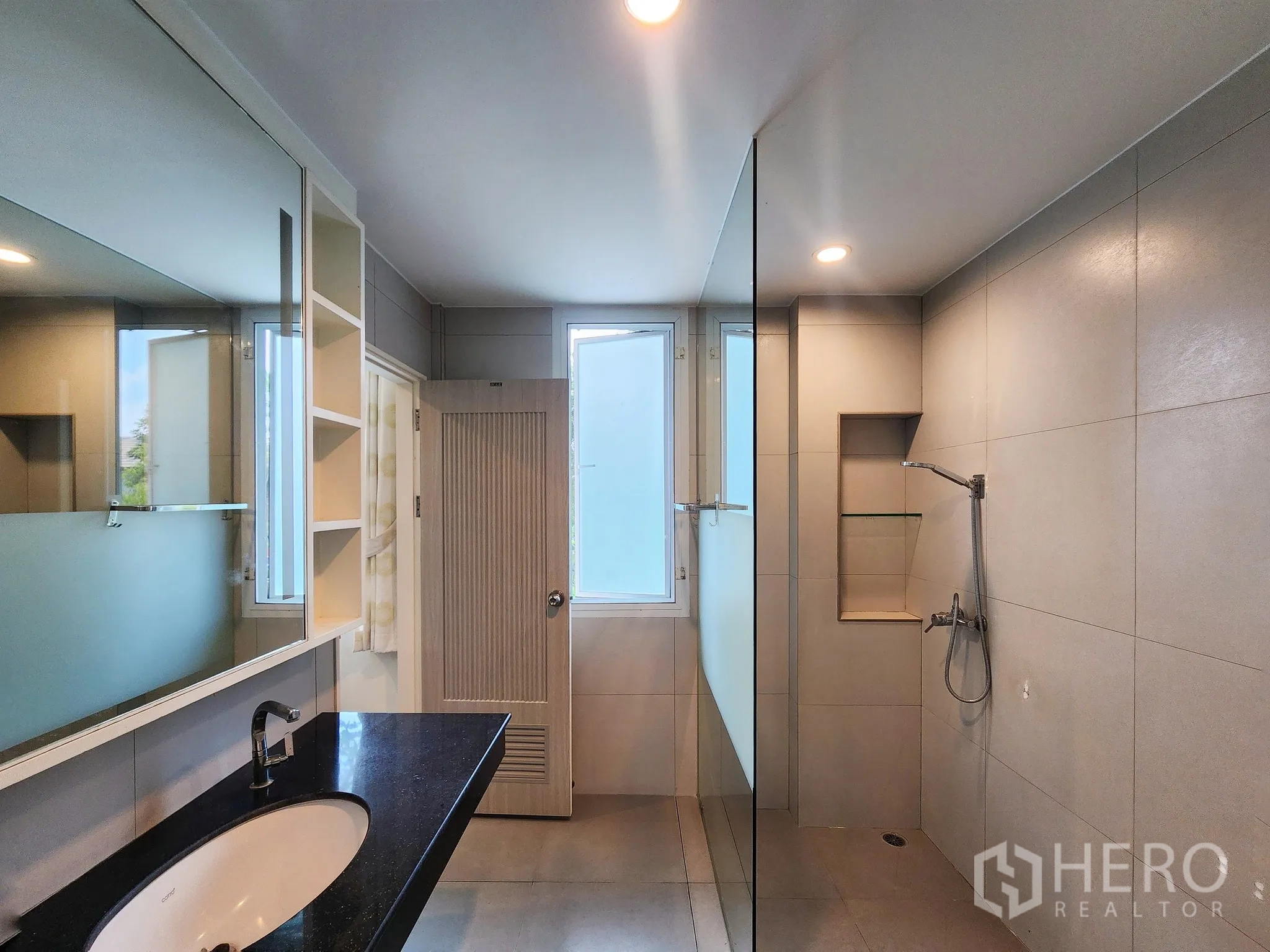 Detached House for rent in Bang Kapi, Bangkok - Spacious bathroom with walk-in shower, built-in niche and natural light.