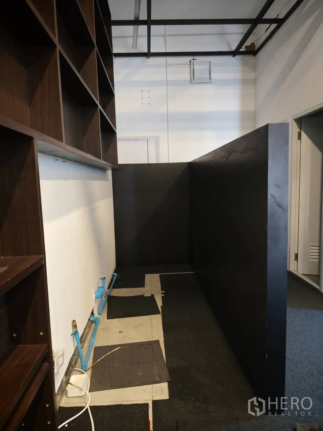 零售空间 for rent in Watthana, Bangkok - 另一角度展示带搁架和墙面管道的功能区。