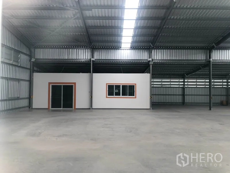Warehouse for rent in Mueang Nonthaburi, Nonthaburi - Interior of the warehouse with high ceiling, skylight strip, polished concrete floor and built-in office rooms.