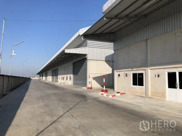 Warehouse for rent in Lam Luk Ka, Pathum Thani - Modern warehouse block in Lam Luk Ka with covered loading bays and a wide concrete driveway.