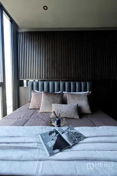 Condominium for sale - Second bedroom with slatted wood headboard and soft neutral bedding.