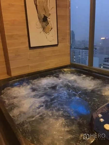 公寓 出租在Watthana, Bangkok - 室内漩涡按摩池，临落地窗可观城市景观。