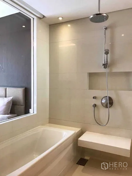 Condominium for rent in Watthana, Bangkok - Spa-style bathroom featuring a bathtub, rain shower and window to the bedroom.