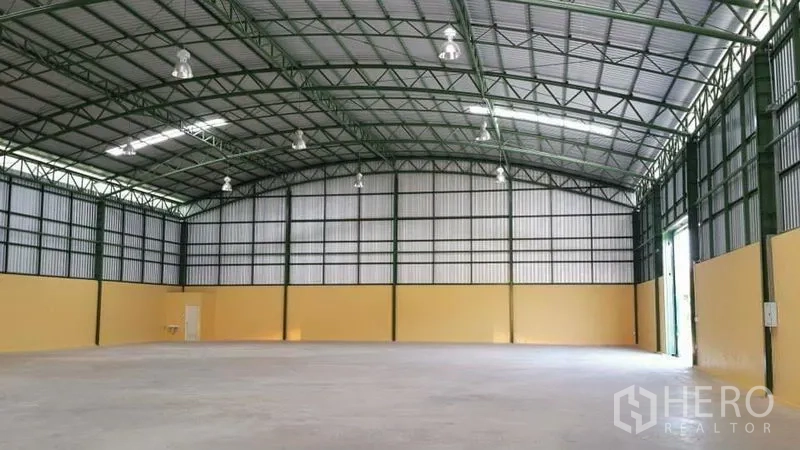 Warehouse for rent in Lat Krabang, Bangkok - Open warehouse hall with smooth concrete flooring and bright high-bay lighting under a steel roof.
