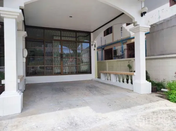 独立式住宅 出租在Khlong Toei, Bangkok - 带顶车棚与拱形立柱，旁有大面积窗墙的停车空间。