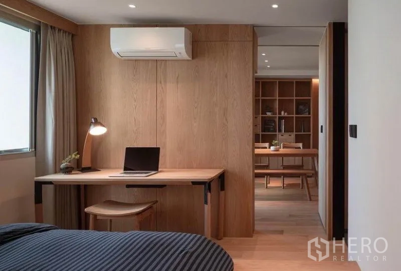 Condominium for rent in Phaya Thai, Bangkok - Bedroom workspace with desk and air conditioner looking toward the living and dining area.