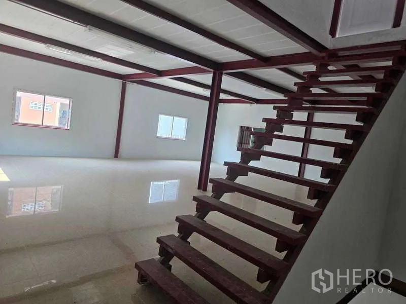 Warehouse for rent in Mueang Samut Sakhon, Samut Sakhon - Open mezzanine level with red steel beams and windows, viewed from the foot of the stairs.