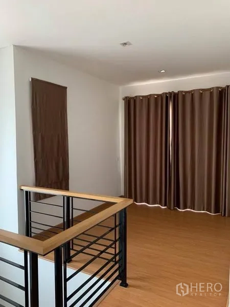 Detached House for sale in Suan Luang, Bangkok - Upper landing family space with wood floors and full-length drapes.