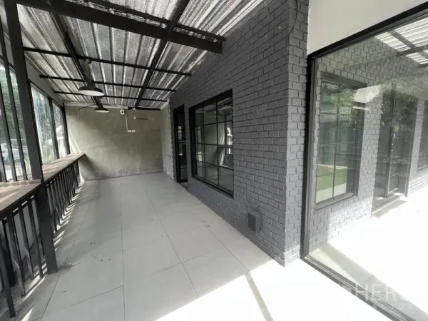 Retail Space for rent in Watthana, Bangkok - Covered glass-fronted terrace with black brick wall and windows facing the street.