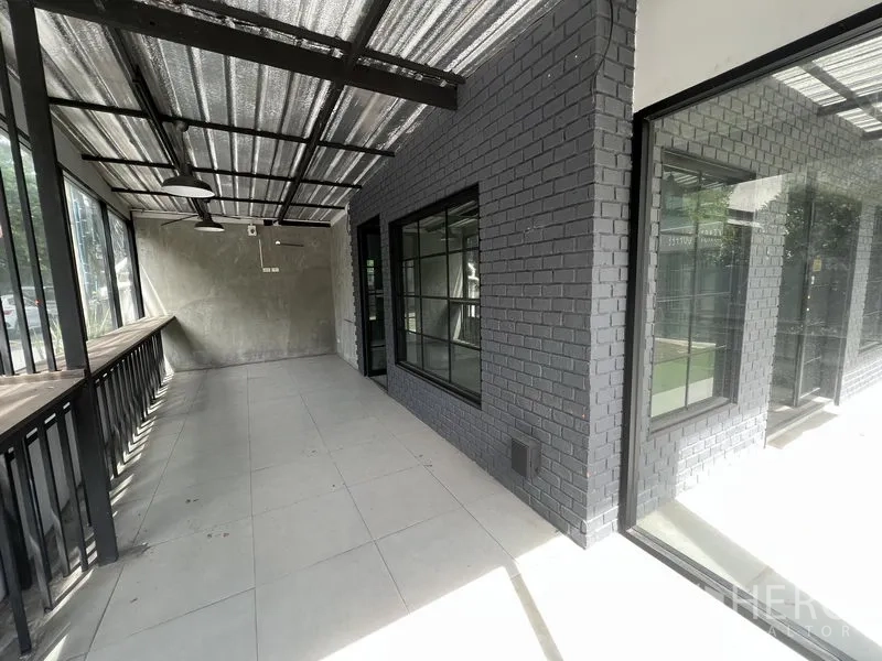Retail Space for rent in Watthana, Bangkok - Covered glass-fronted terrace with black brick wall and windows facing the street.