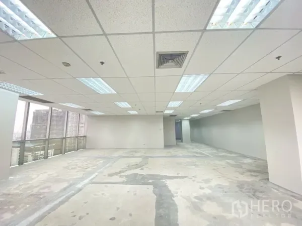 Office Space for rent in Chatuchak, Bangkok - Large rectangular office floor plate with grid ceiling, fluorescent lights and city views from tall windows.