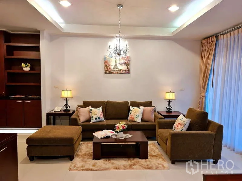 Apartment for rent - Living area with chandelier, sofa set and built-in cabinetry.
