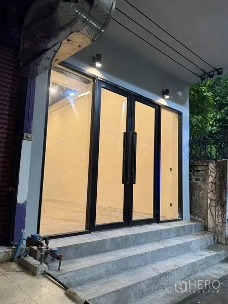 Shophouse for rent - Ground‑floor glass storefront entrance with double doors and steps, ideal for retail or showroom use.