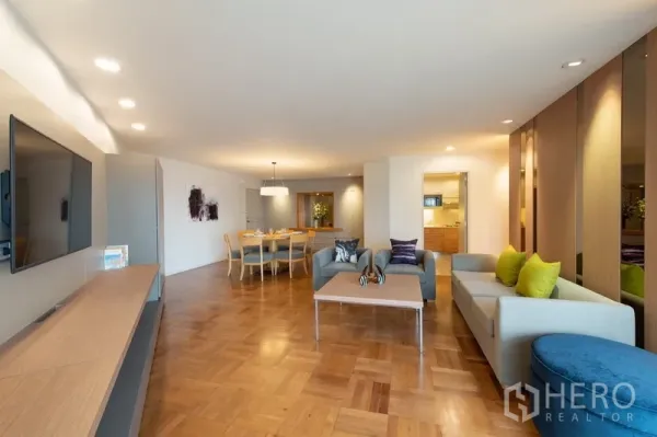 Apartment for rent in Yan Nawa, Bangkok - Open-plan living room with parquet flooring, built-in TV console, and modern sofas in a Yan Nawa apartment.
