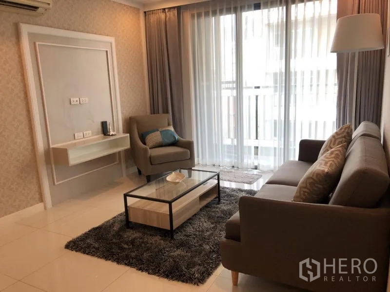 公寓 出租在Watthana, Bangkok - 现代客厅，沙发与单椅、长绒地毯、玻璃茶几，落地窗通向阳台。