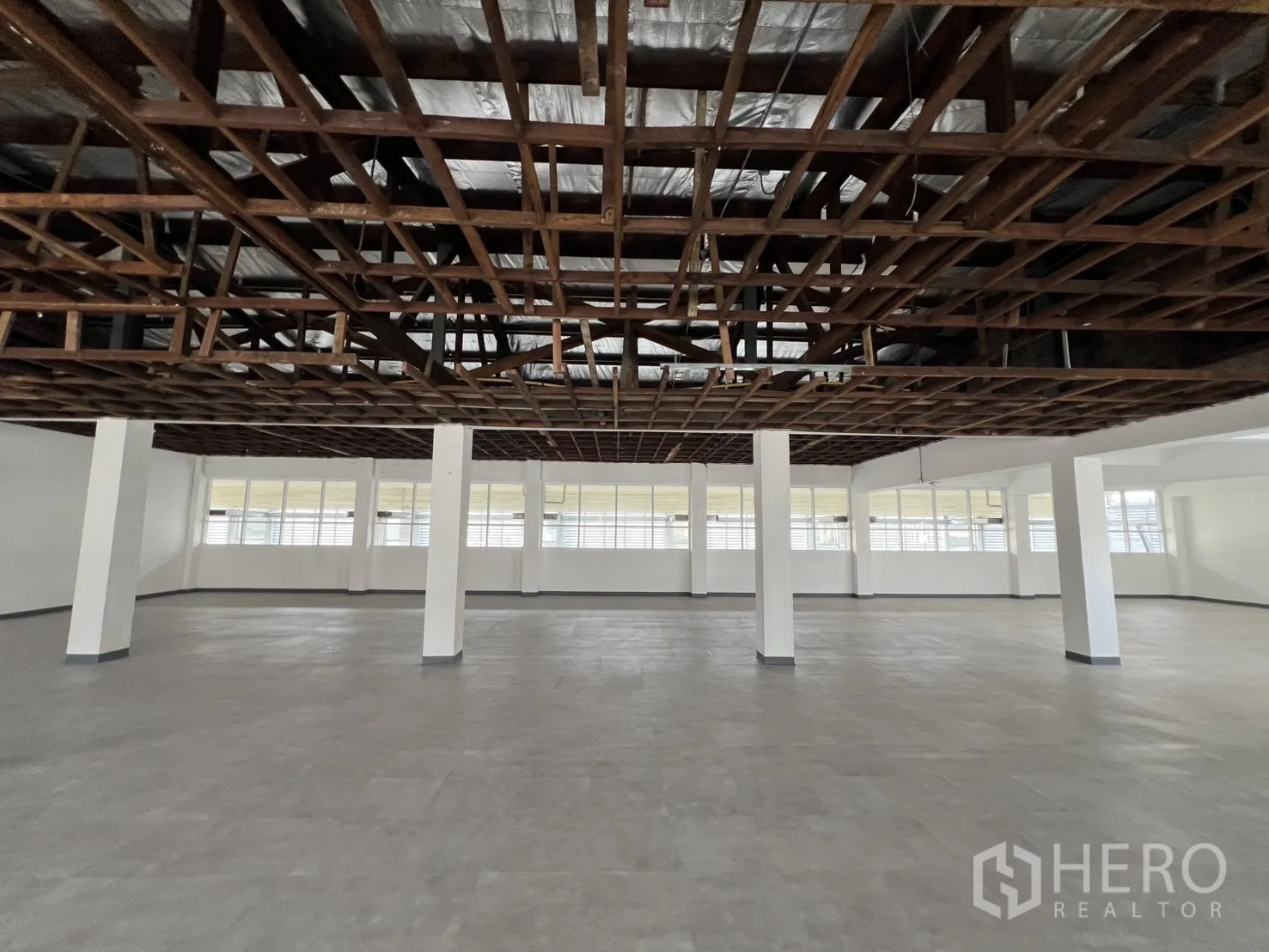办公空间 出租在Watthana, Bangkok - 开阔工作区，灰色地面与保温层上方的天花网格，自然光充足。