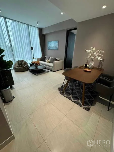 Condominium for rent in Bang Rak, Bangkok - Living and dining area with large windows and neutral contemporary décor