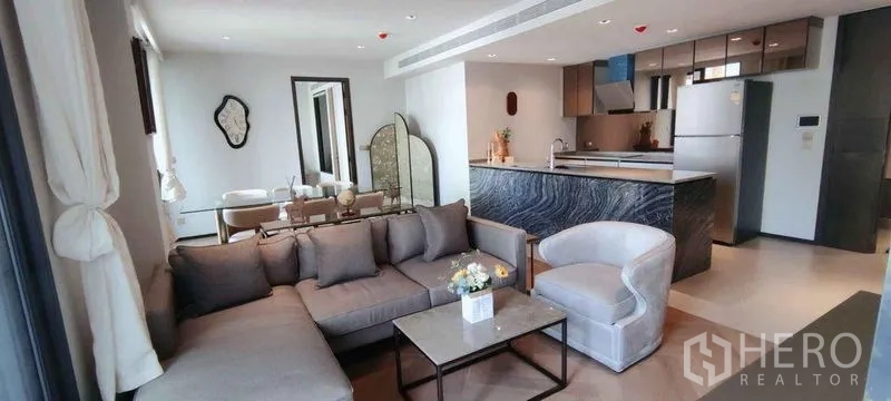 公寓 出租在Watthana, Bangkok - 宽敞客厅相连餐区与蓝纹岛台厨房。