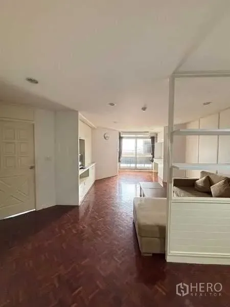 Condominium for rent - Bright living room with parquet floors, built-in TV wall and balcony in a Bangkok condo near BTS Ekkamai.