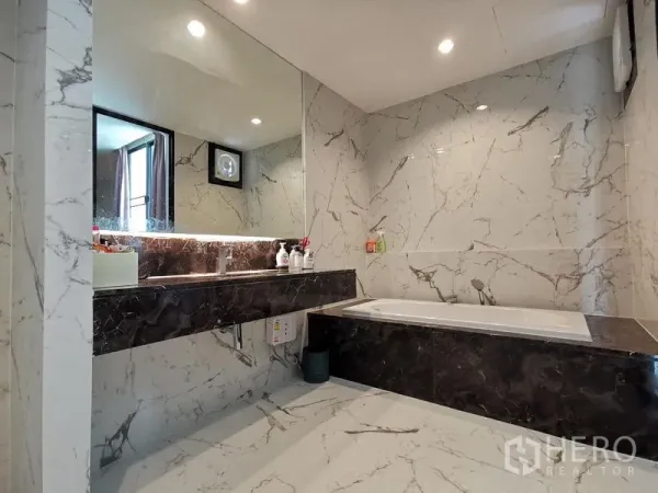 Townhouse for sale - Modern marble bathroom with long vanity, oversized mirror and a built-in bathtub.