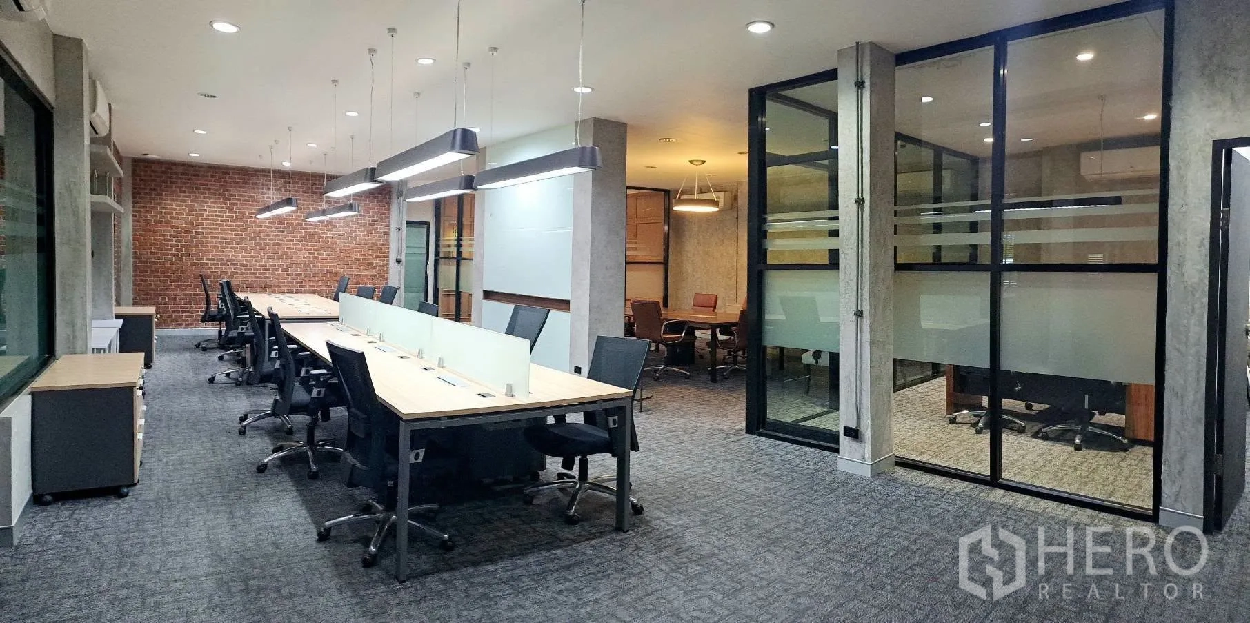 Home Office for rent in Lat Phrao, Bangkok - Work area with glass-partitioned meeting rooms and ergonomic chairs.