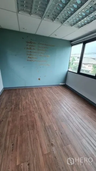 办公空间 出租在Watthana, Bangkok - 独立办公室，蓝色特色墙、木地板与城市景观。