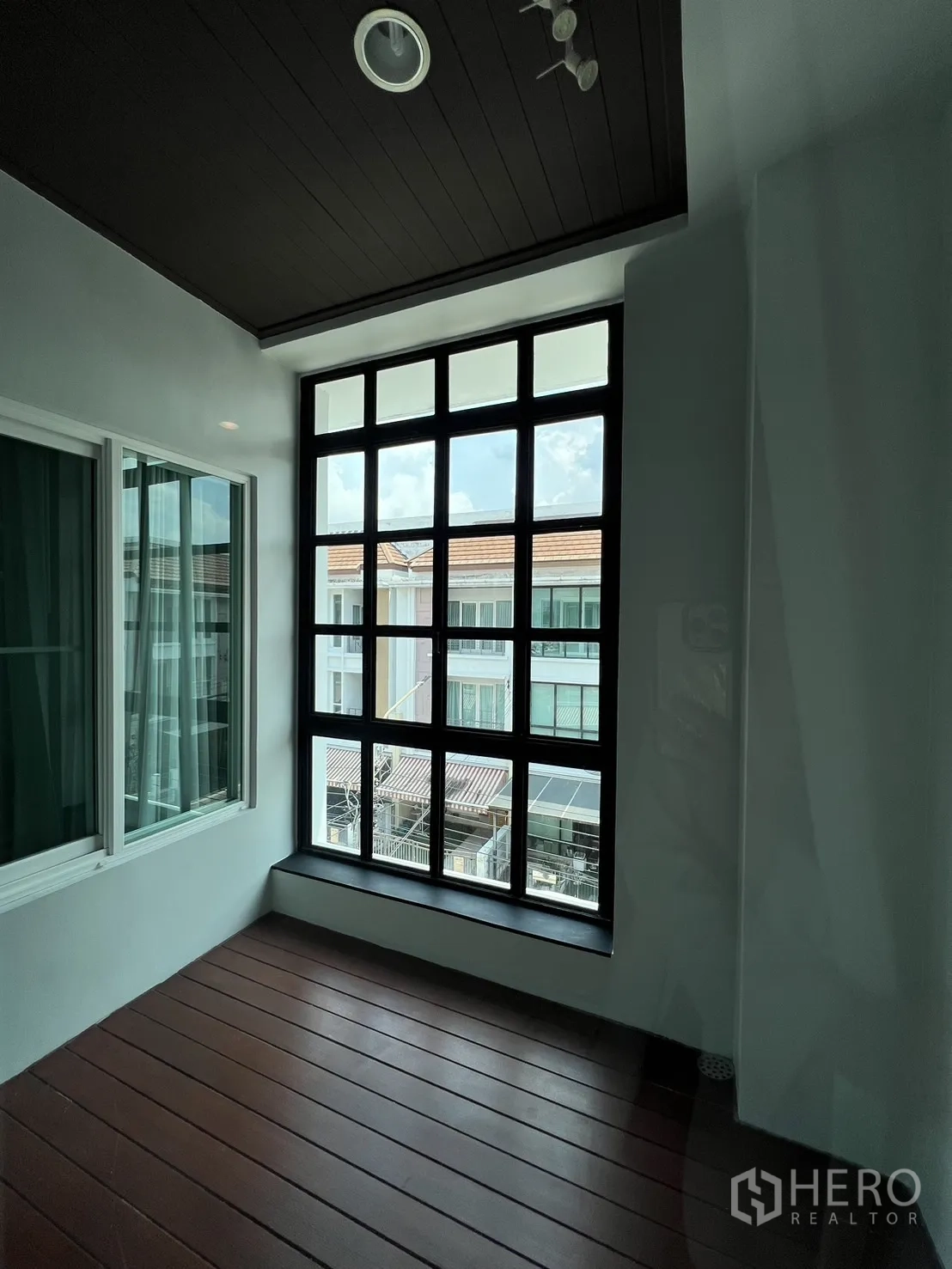 联排别墅 出租在Wang Thonglang, Bangkok - 封闭阳台/日光房，大格栅窗与木纹地面。