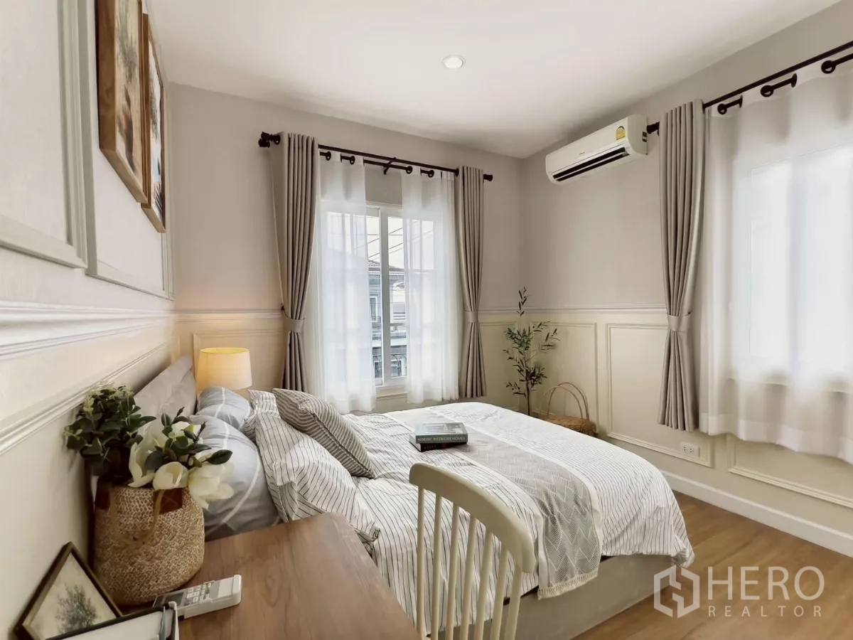Detached House for rent in Khlong Luang, Pathum Thani - Bright guest bedroom with bed, desk, windows and air conditioner