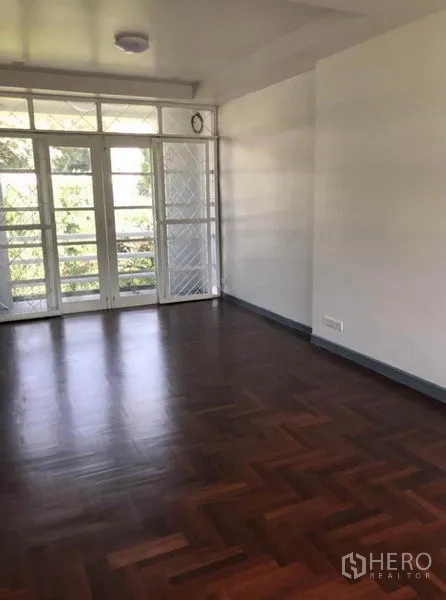 Townhouse for rent in Suan Luang, Bangkok - Bright room with parquet wood flooring and French doors opening to a balcony.