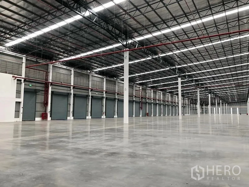 Factory for rent in Wang Noi, Phra Nakhon Si Ayutthaya - High-bay warehouse interior with polished concrete floor, columns, and fire-sprinkler piping.